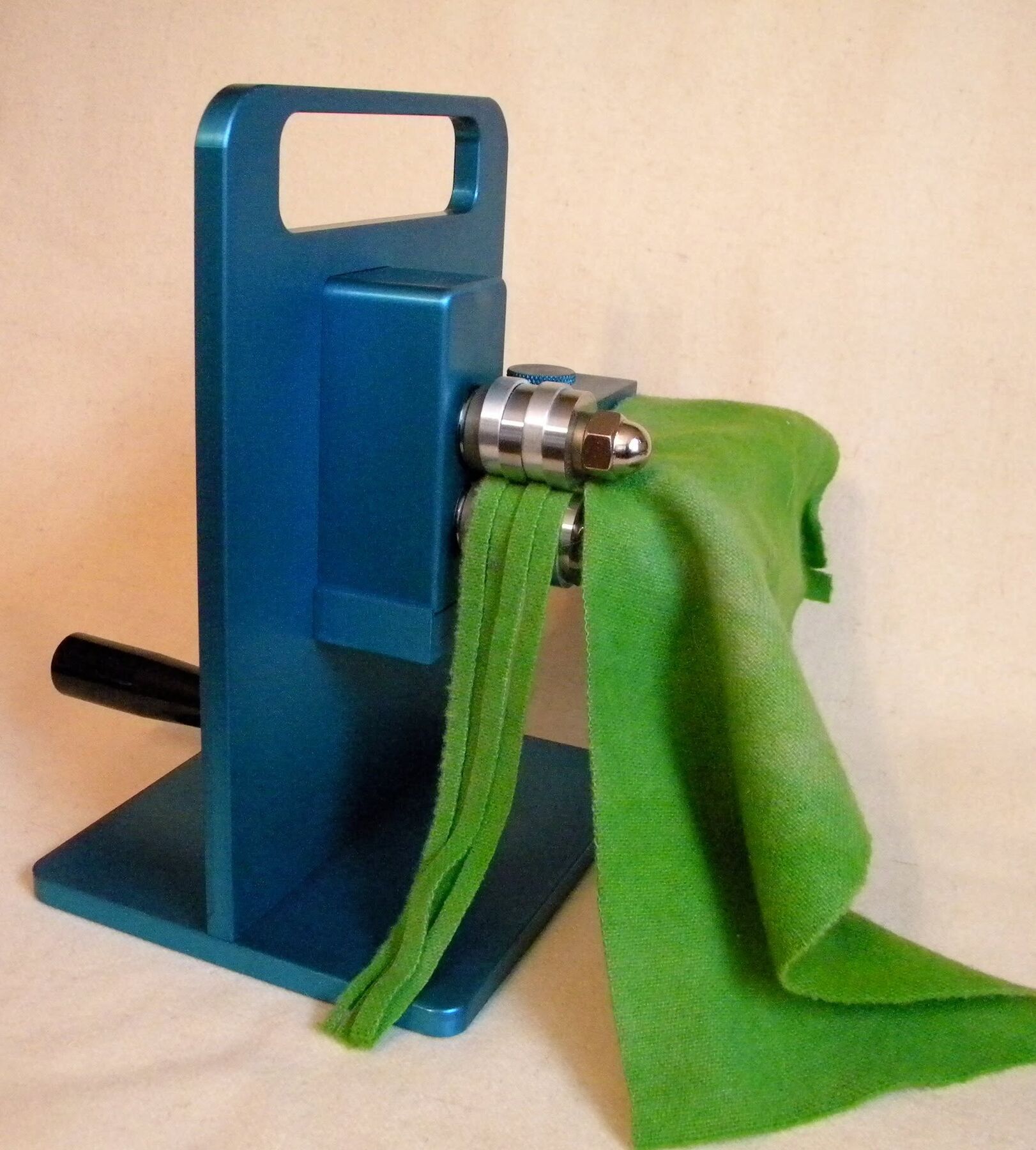 Green wool passing through a Honeydoo cutter and emerging as four evenly cut strips Green wool passing through a Honeydoo cutter and emerging as four evenly cut strips